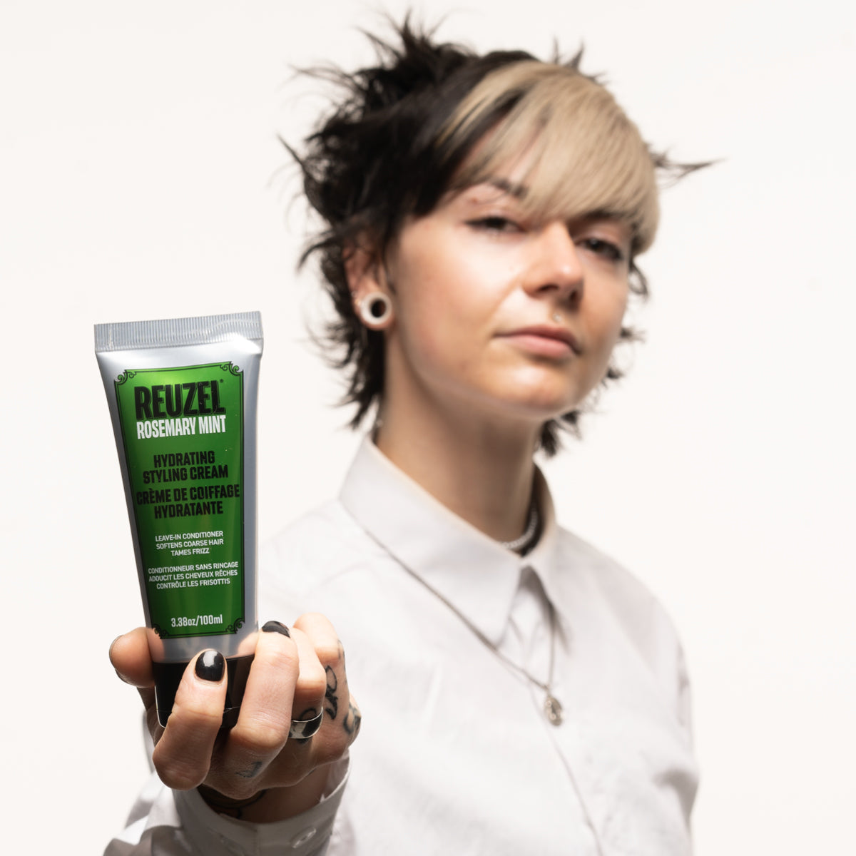 Reuzel Hydrating Styling Cream in use on a model's hair, showcasing smooth texture and shine for styling.
