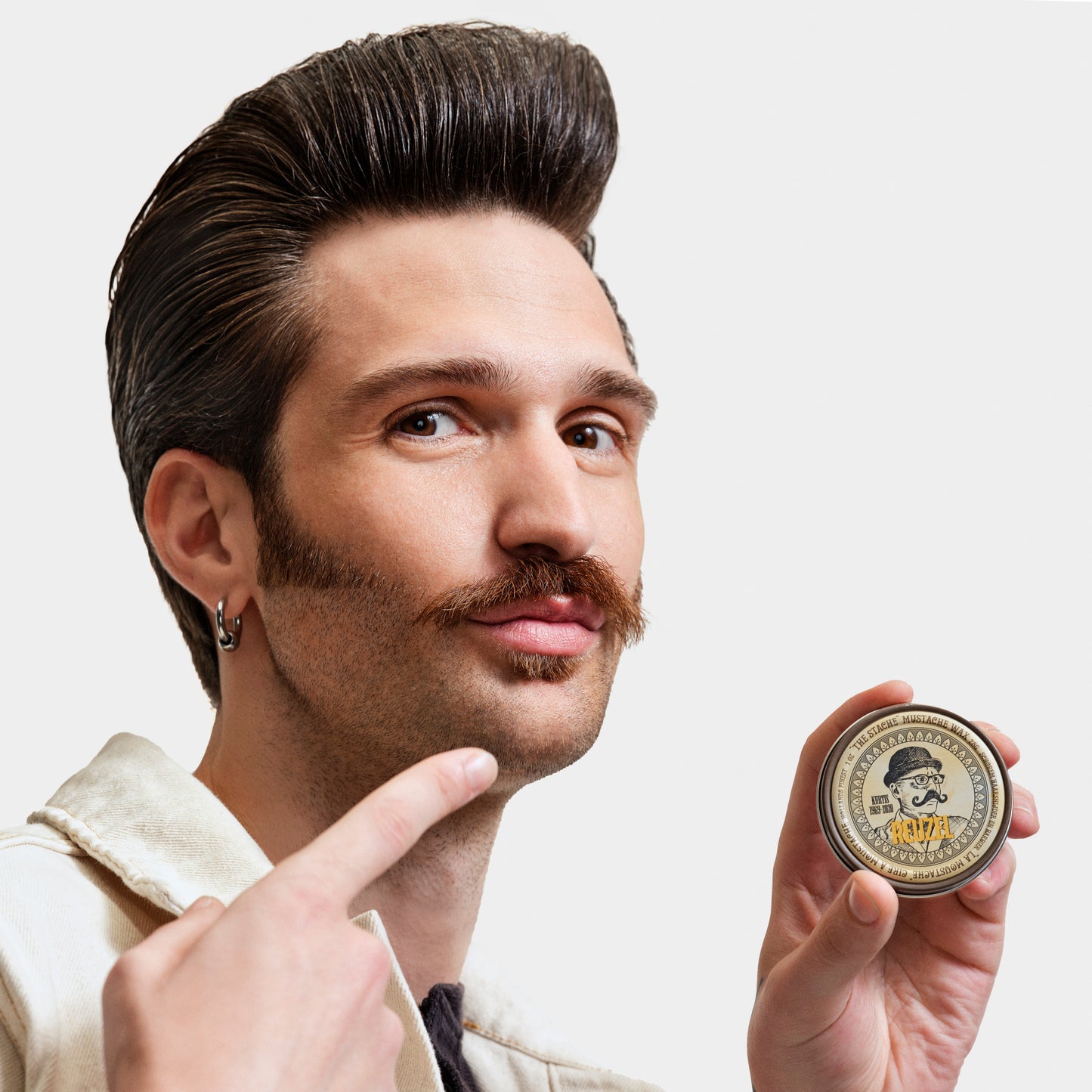 Reuzel The Stache Mustache Wax in a small tin, designed for shaping and styling mustaches with a natural finish.